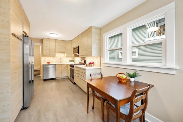 50 S Marquette St, Madison, WI 53704 - kitchen featuring stainless steel appliances, light brown cabinets, light countertops, decorative backsplash, and modern cabinets