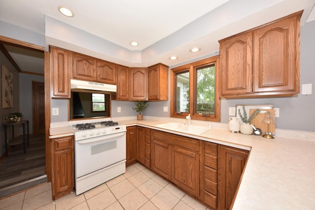 8535 N 59th St, Brown Deer, WI 53223 - kitchen featuring white range with gas cooktop, under cabinet range hood, light countertops, healthy amount of natural light, and recessed lighting