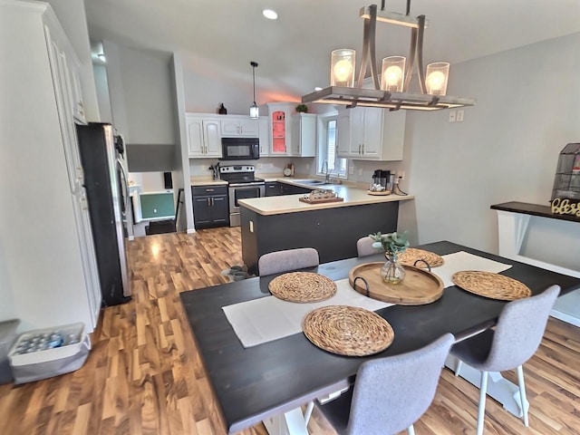 3201 Mockingbird Way, Oshkosh, WI 54904 - dining space with light wood-type flooring, a chandelier, and vaulted ceiling