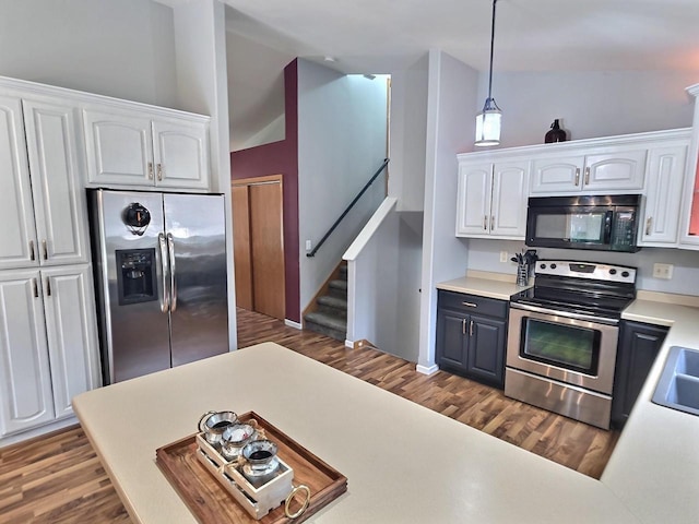 3201 Mockingbird Way, Oshkosh, WI 54904 - kitchen featuring stainless steel appliances, white cabinetry, dark wood-style flooring, lofted ceiling, and light countertops