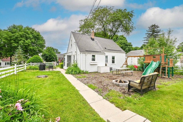 2750 N 86th St, Milwaukee, WI 53222 - back of property featuring a fire pit, a chimney, a playground, a shingled roof, and a patio area