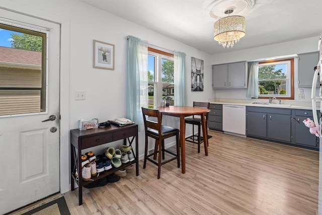 605 E 10th St, Fond Du Lac, WI 54935 - kitchen featuring white dishwasher, gray cabinetry, light wood finished floors, and healthy amount of natural light