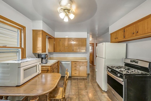 1128 S 62nd St, West Allis, WI 53214 - kitchen with appliances with stainless steel finishes, ceiling fan, light countertops, and brown cabinetry