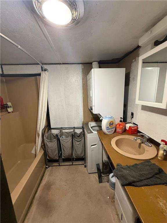1330 21 3/4 St Unit A, Cameron, WI 54822 - bathroom with stacked washer / drying machine, unfinished concrete floors, shower / bath combo, and vanity