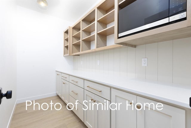 2584 N Stellita Cir, De Pere, WI 54115 - kitchen featuring stainless steel microwave, light wood-style flooring, white cabinetry, light countertops, and open shelves
