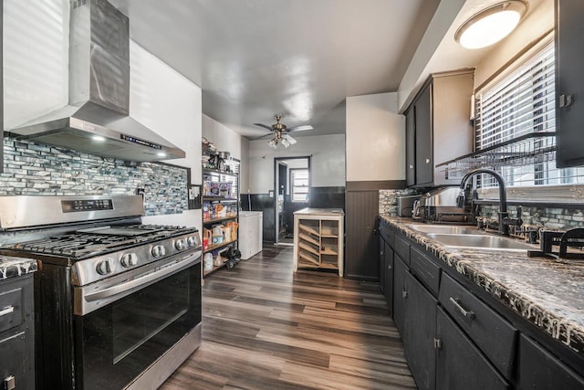 500 S Pierce Ave, Appleton, WI 54914 - kitchen with stainless steel gas range, wall chimney exhaust hood, ceiling fan, dark wood-style flooring, and decorative backsplash