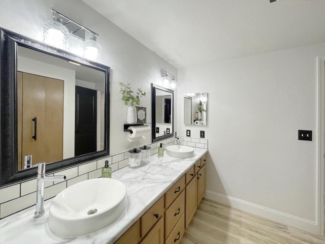 431 Limestone St, Kiel, WI 53042 - bathroom featuring double vanity, wood finished floors, and tasteful backsplash