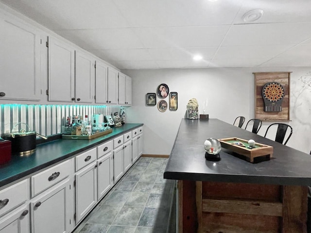431 Limestone St, Kiel, WI 53042 - kitchen featuring dark countertops, a peninsula, a paneled ceiling, and white cabinetry