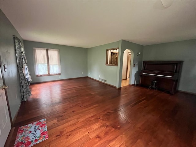 514 S Robert St, Grantsburg, WI 54840 - unfurnished living room featuring hardwood / wood-style floors and arched walkways