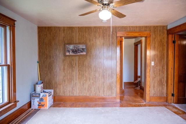 318 Tremont St, Mauston, WI 53948 - spare room featuring ceiling fan, wooden walls, and wood finished floors