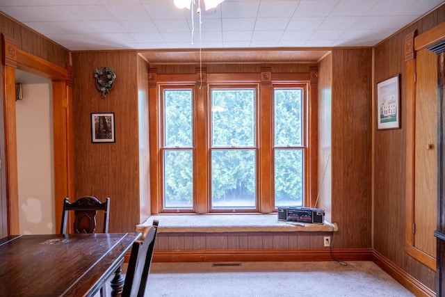 318 Tremont St, Mauston, WI 53948 - carpeted dining space with wooden walls and plenty of natural light