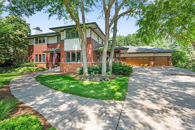 5870 Persimmon Dr, Fitchburg, WI 53711 - view of front of home featuring a chimney, concrete driveway, a garage, and brick siding