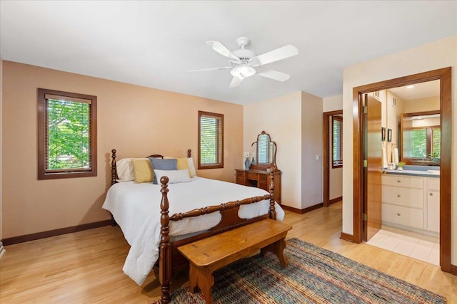 5870 Persimmon Dr, Fitchburg, WI 53711 - bedroom with light wood-style flooring, multiple windows, connected bathroom, and a ceiling fan