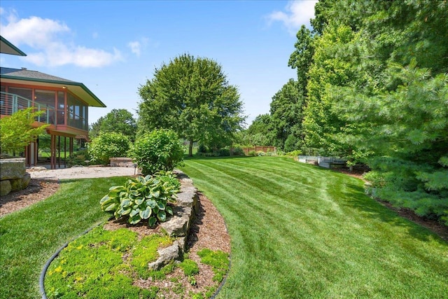 5870 Persimmon Dr, Fitchburg, WI 53711 - view of green lawn with a sunroom and a patio area