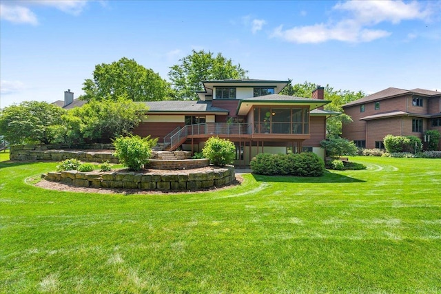 5870 Persimmon Dr, Fitchburg, WI 53711 - rear view of property featuring a sunroom, a chimney, a lawn, stairs, and a wooden deck