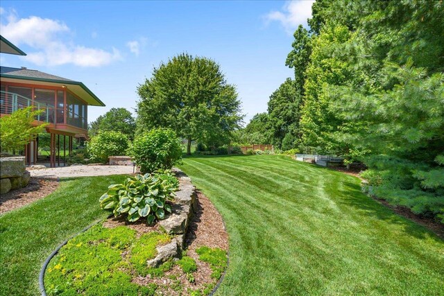 5870 Persimmon Dr, Fitchburg, WI 53711 - view of green lawn with a sunroom and a patio area