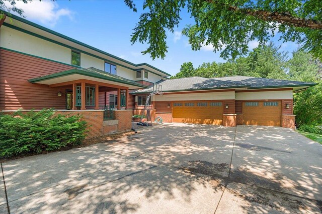 5870 Persimmon Dr, Fitchburg, WI 53711 - view of front of property featuring brick siding, driveway, a garage, and covered porch