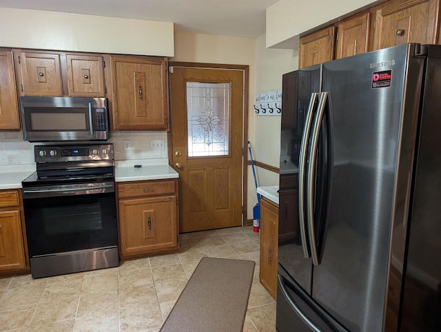 3664 Martin Rd, Kronenwetter, WI 54455 - kitchen featuring freestanding refrigerator, stainless steel microwave, electric stove, light countertops, and brown cabinets
