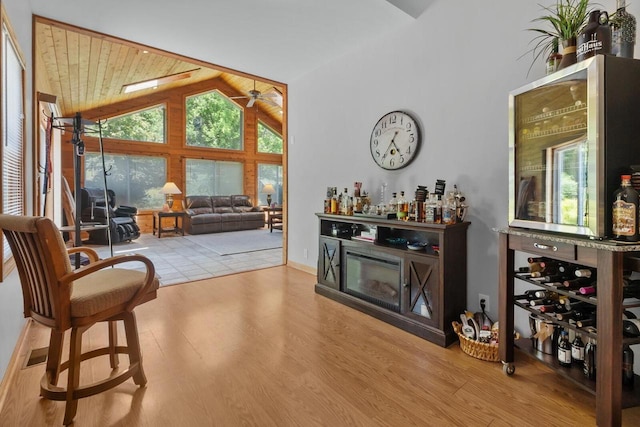 1201 Lance Dr, Twin Lakes, WI 53181 - living area featuring a bar, a ceiling fan, wood finished floors, and high vaulted ceiling