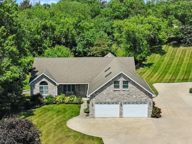 1201 Lance Dr, Twin Lakes, WI 53181 - view of front of house with stone siding, driveway, a front lawn, and roof with shingles