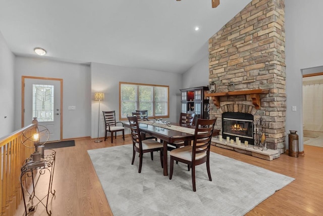1201 Lance Dr, Twin Lakes, WI 53181 - dining space featuring high vaulted ceiling, a stone fireplace, and wood finished floors