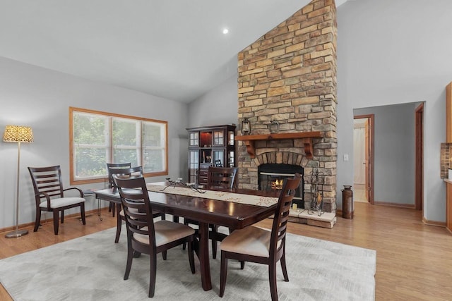 1201 Lance Dr, Twin Lakes, WI 53181 - dining area with high vaulted ceiling, light wood-type flooring, and a stone fireplace