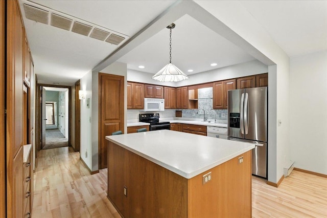 3107 Harbor Village Rd Unit 1, Middleton, WI 53562 - kitchen with white appliances, light wood finished floors, light countertops, backsplash, and a center island