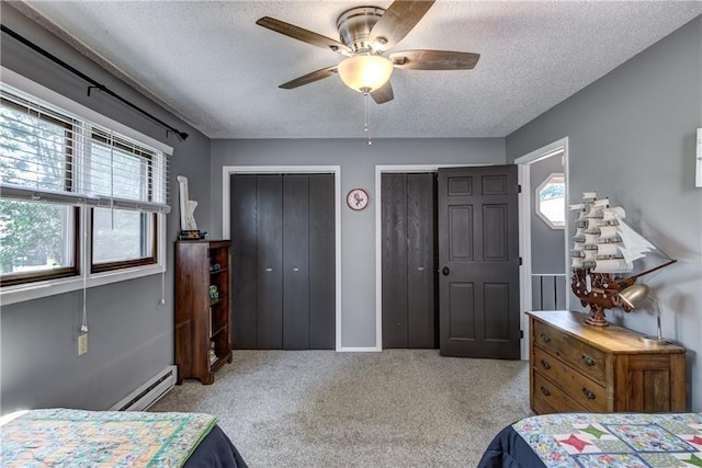45 Stump Lake Rd Unit 6, Chippewa Falls, WI 54729 - bedroom with two closets, a textured ceiling, a baseboard radiator, multiple windows, and carpet floors