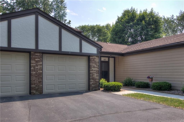 45 Stump Lake Rd Unit 6, Chippewa Falls, WI 54729 - view of front of house with stucco siding, driveway, brick siding, and a garage