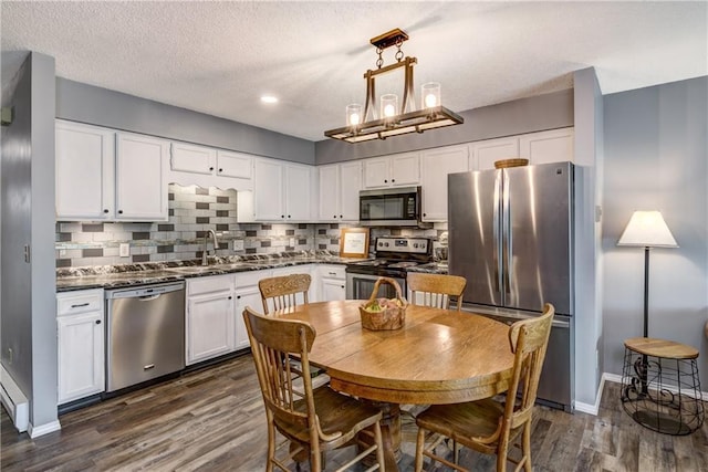 45 Stump Lake Rd Unit 6, Chippewa Falls, WI 54729 - kitchen with appliances with stainless steel finishes, dark countertops, white cabinets, dark wood-style flooring, and backsplash