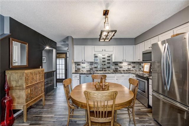 45 Stump Lake Rd Unit 6, Chippewa Falls, WI 54729 - kitchen with appliances with stainless steel finishes, dark countertops, a textured ceiling, white cabinets, and tasteful backsplash