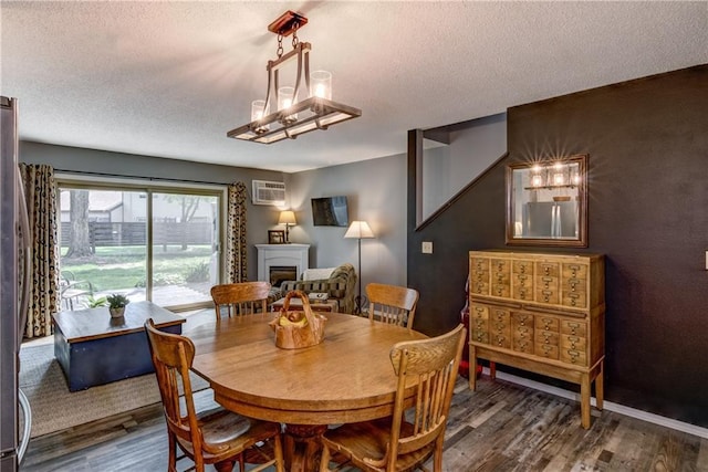 45 Stump Lake Rd Unit 6, Chippewa Falls, WI 54729 - dining area with a textured ceiling, wood finished floors, a fireplace, and a wall unit AC