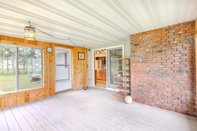 7040 Blonien Ave, Rudolph, WI 54475 - unfurnished sunroom featuring brick wall, wood-type flooring, and wooden walls