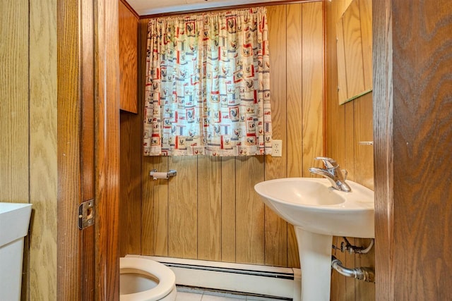 7040 Blonien Ave, Rudolph, WI 54475 - half bath featuring a baseboard radiator, wooden walls, and tile patterned floors