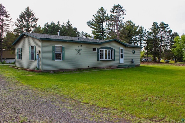68165 Front St, Iron River, WI 54847 - back of house featuring a lawn and gravel driveway