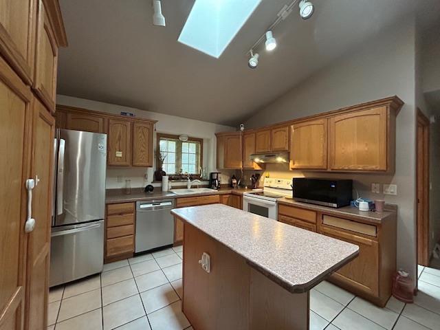5201 Lombardy Dr, Wausau, WI 54401 - kitchen with stainless steel appliances, vaulted ceiling, a skylight, a center island, and under cabinet range hood
