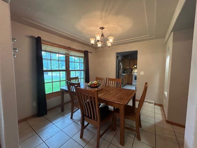 5201 Lombardy Dr, Wausau, WI 54401 - dining room featuring a chandelier, a raised ceiling, and light tile patterned flooring