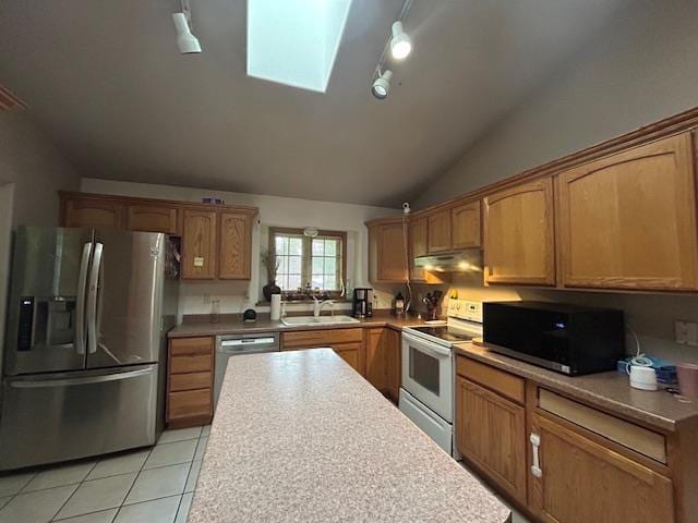5201 Lombardy Dr, Wausau, WI 54401 - kitchen with appliances with stainless steel finishes, a skylight, under cabinet range hood, vaulted ceiling, and light tile patterned floors