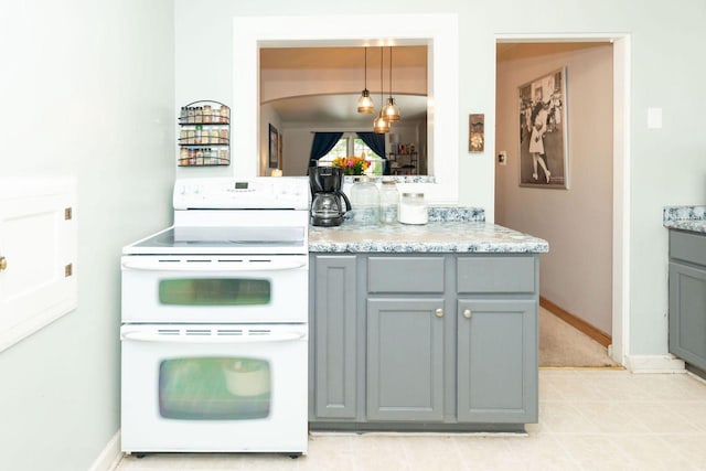 6533 W Center St, Wauwatosa, WI 53210 - kitchen featuring range with two ovens, gray cabinets, pendant lighting, and light stone countertops