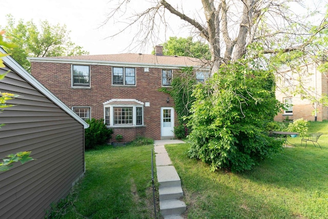 6533 W Center St, Wauwatosa, WI 53210 - view of front facade featuring brick siding, a front lawn, and a chimney