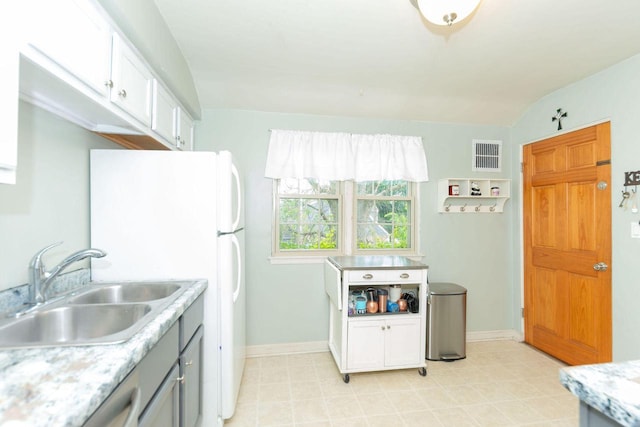 6533 W Center St, Wauwatosa, WI 53210 - kitchen featuring light countertops, freestanding refrigerator, white cabinets, vaulted ceiling, and gray cabinetry