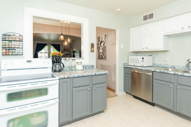 6533 W Center St, Wauwatosa, WI 53210 - kitchen with white appliances, gray cabinetry, white cabinets, and pendant lighting