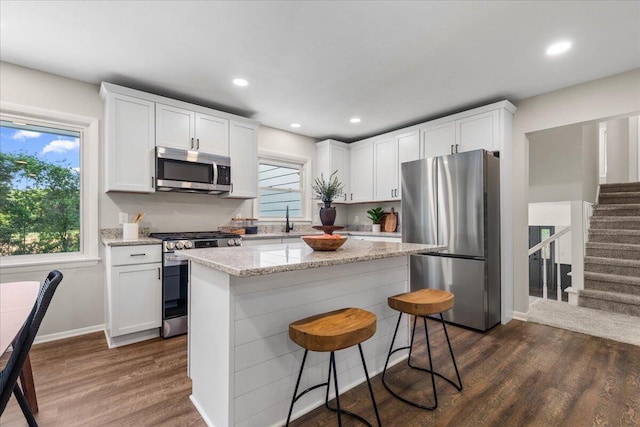 N113W20588 Edgewood Dr, Germantown, WI 53022 - kitchen featuring appliances with stainless steel finishes, dark wood finished floors, white cabinetry, recessed lighting, and a center island