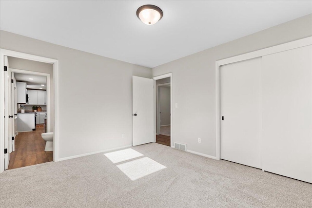 N113W20588 Edgewood Dr, Germantown, WI 53022 - unfurnished bedroom featuring carpet flooring, a closet, and connected bathroom
