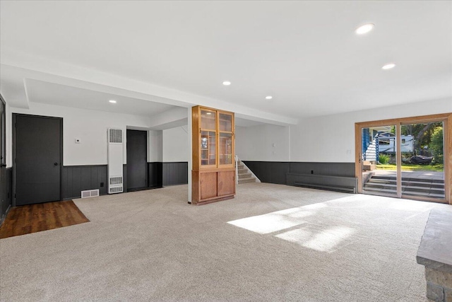 N113W20588 Edgewood Dr, Germantown, WI 53022 - unfurnished living room featuring carpet flooring, stairway, a heating unit, a wainscoted wall, and recessed lighting