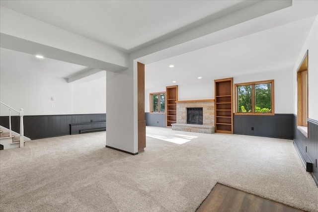 N113W20588 Edgewood Dr, Germantown, WI 53022 - unfurnished living room featuring carpet floors, a stone fireplace, wainscoting, recessed lighting, and stairway