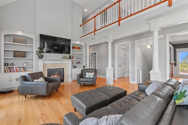 4047 Scenic Rd, Jackson, WI 53037 - living area featuring decorative columns, a towering ceiling, light wood-type flooring, a fireplace, and recessed lighting