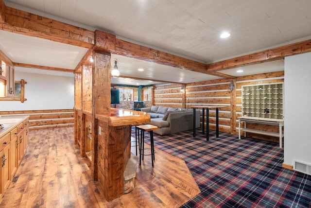 4047 Scenic Rd, Jackson, WI 53037 - kitchen with log walls, a wainscoted wall, recessed lighting, and wooden walls