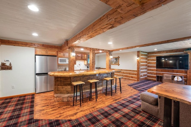 4047 Scenic Rd, Jackson, WI 53037 - kitchen with freestanding refrigerator, white microwave, a kitchen breakfast bar, recessed lighting, and beam ceiling