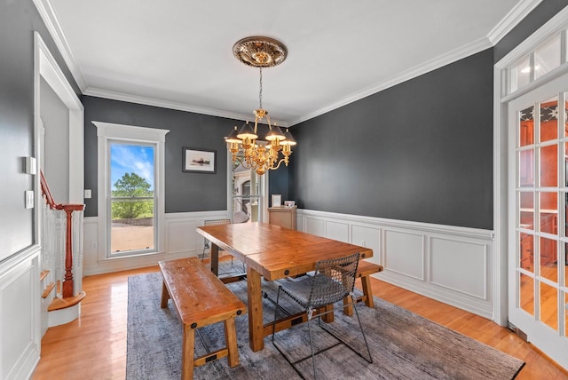 4047 Scenic Rd, Jackson, WI 53037 - dining space with light wood-style flooring, a chandelier, crown molding, wainscoting, and a decorative wall